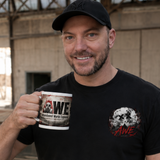 Man holding a mug with 'AWE' logo in an industrial setting
